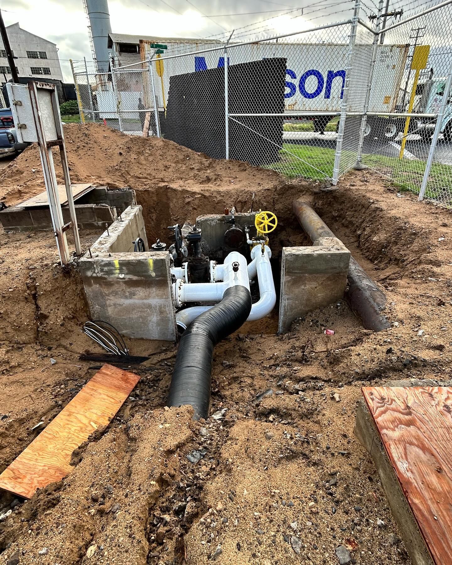 A large hole in the ground with pipes coming out of it.