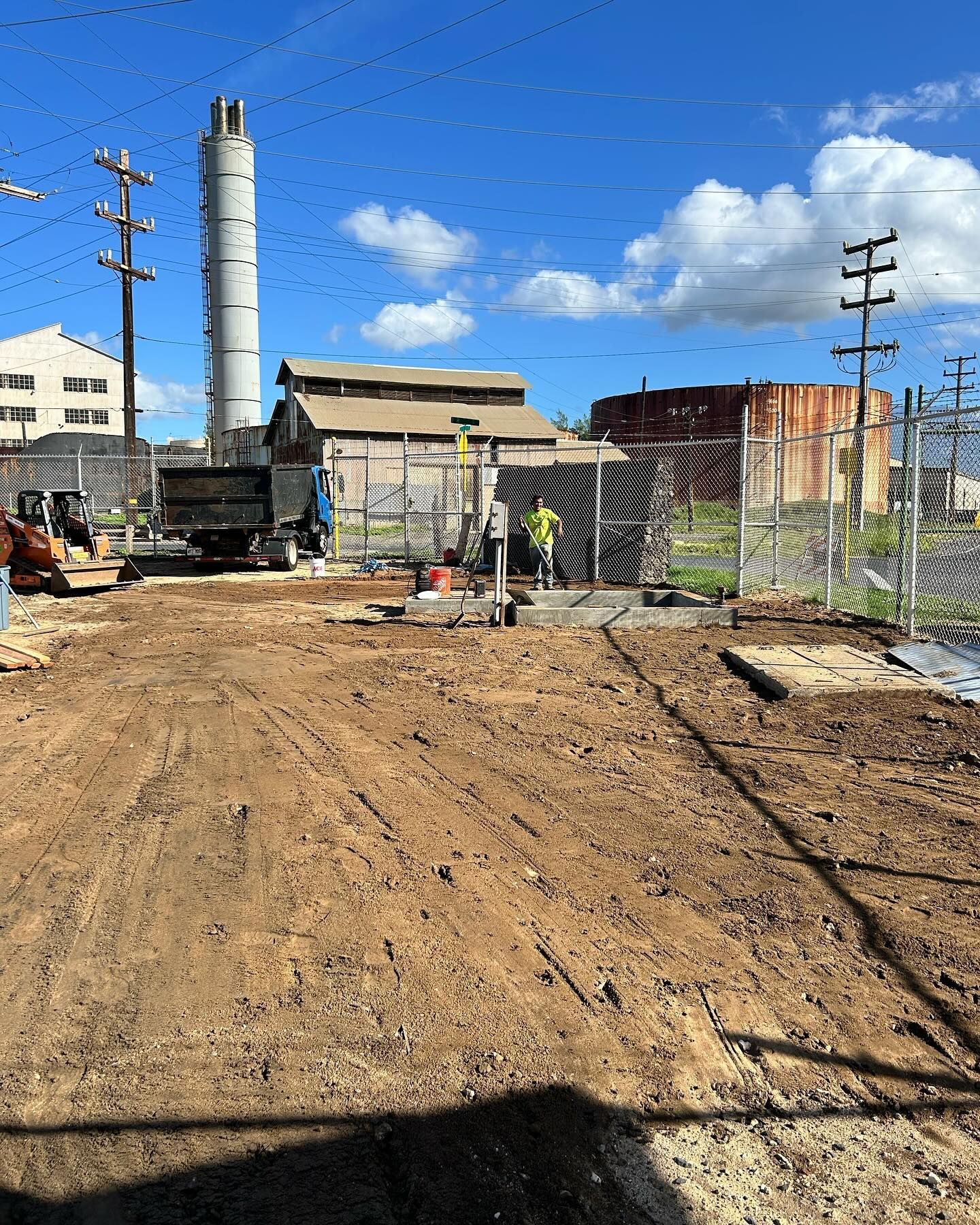 A construction site with a large concrete tower in the background.