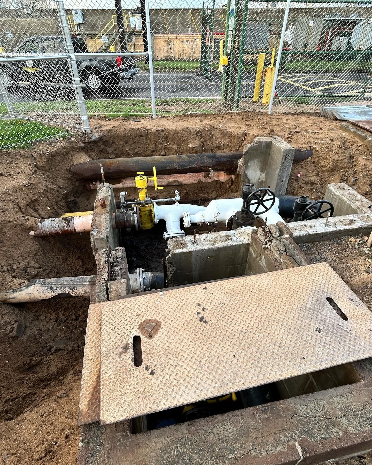 A gas meter is being installed in a hole in the ground.