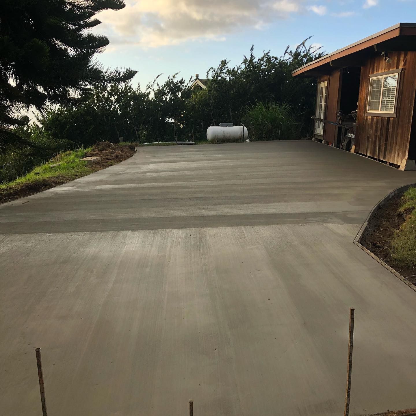 A concrete driveway with a house in the background