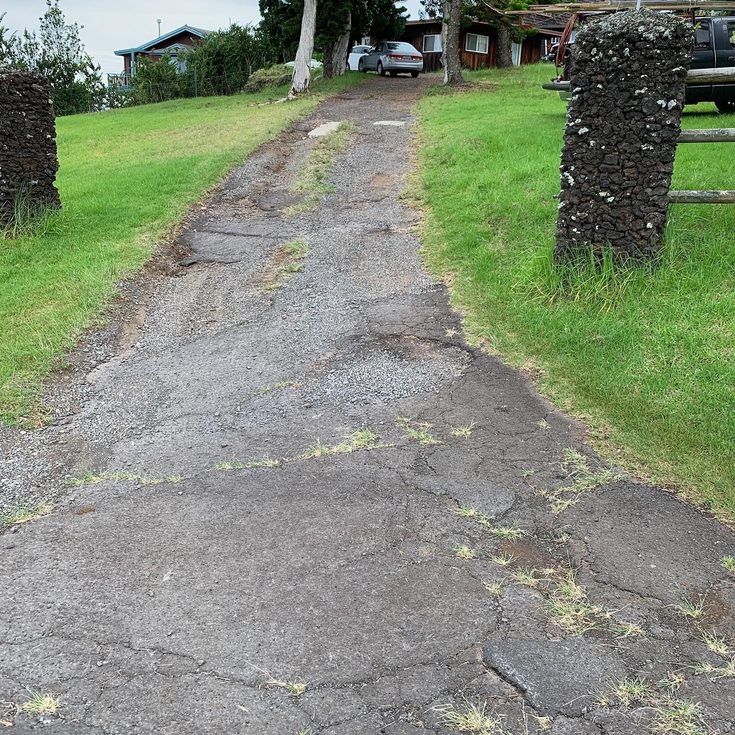 A car is parked on the side of a dirt road