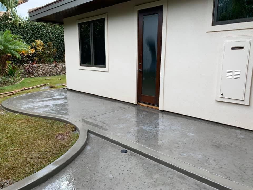 A white house with a concrete walkway leading to it.