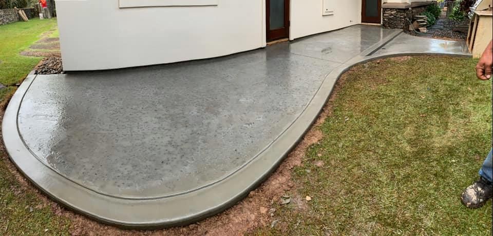 A concrete walkway is being built in front of a house.