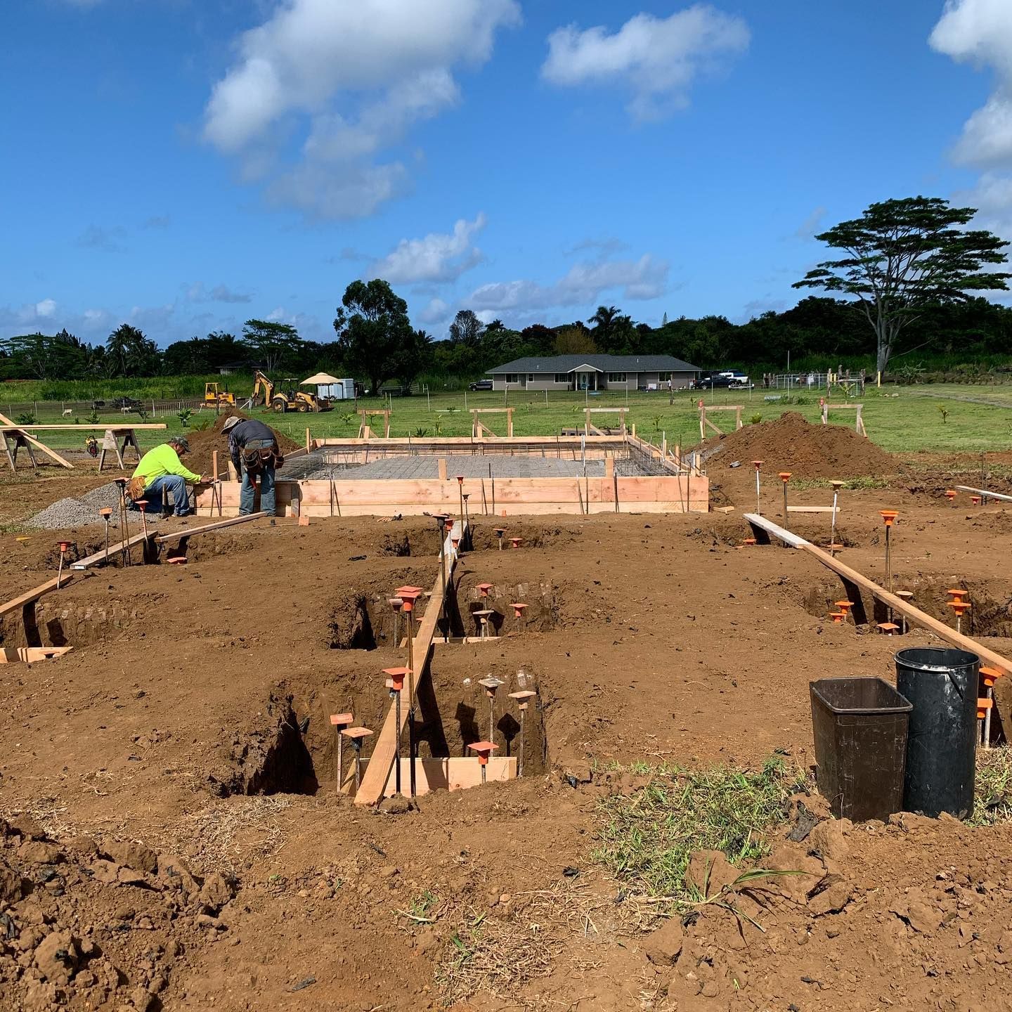 A construction site with a house in the background