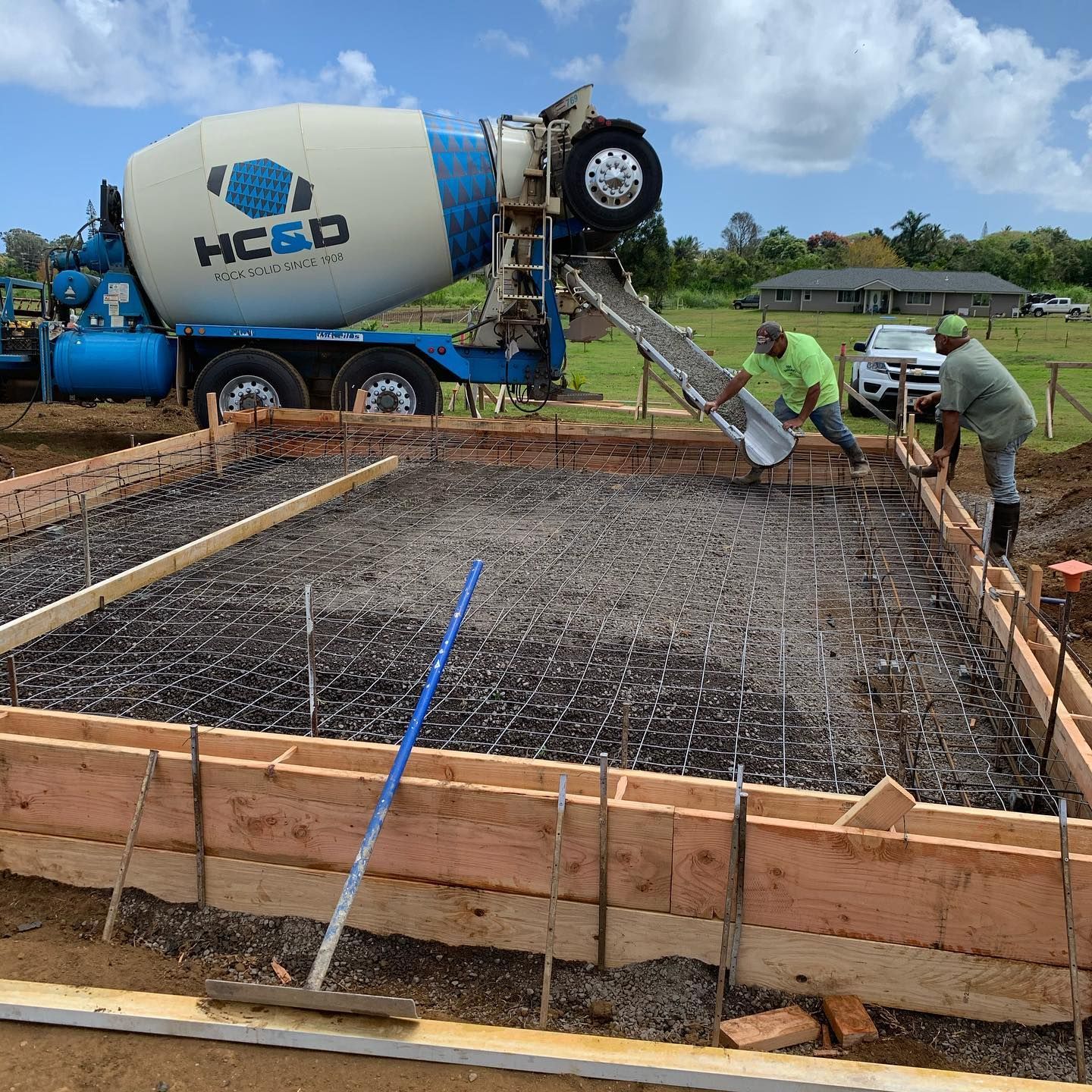 A concrete mixer is pouring concrete into a foundation.