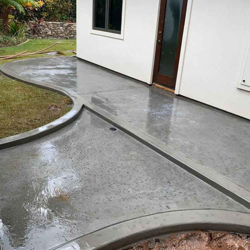 A concrete walkway in front of a white house.