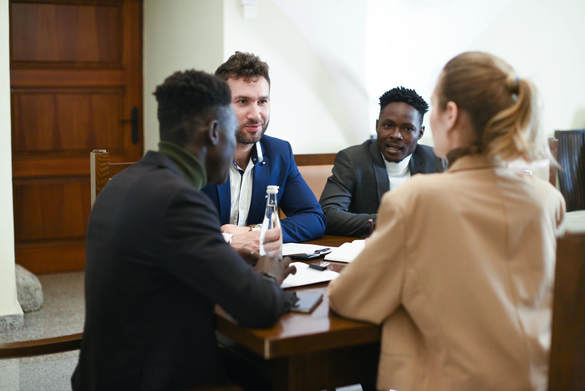 A group of people are sitting around a table having a meeting.