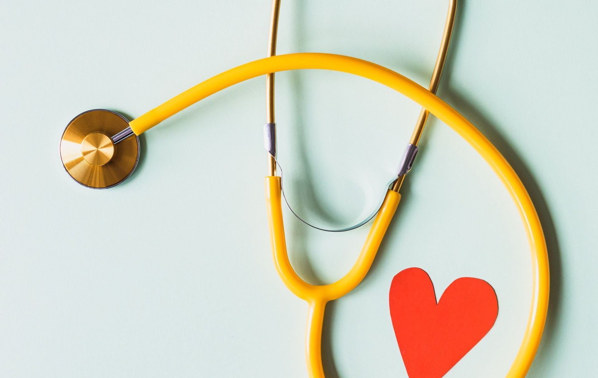 A yellow stethoscope with a red heart on it.