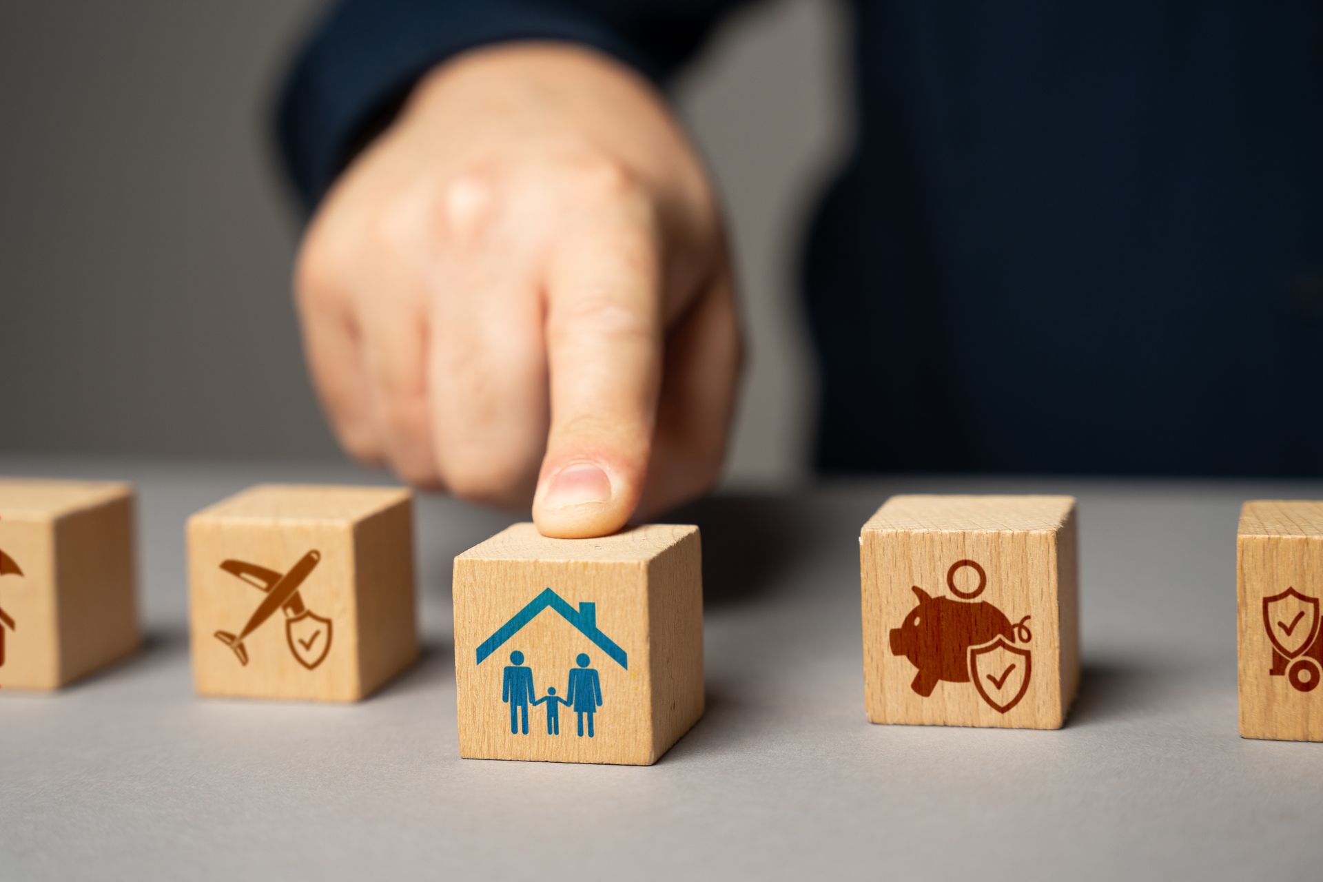 A person is playing with wooden blocks with icons on them.