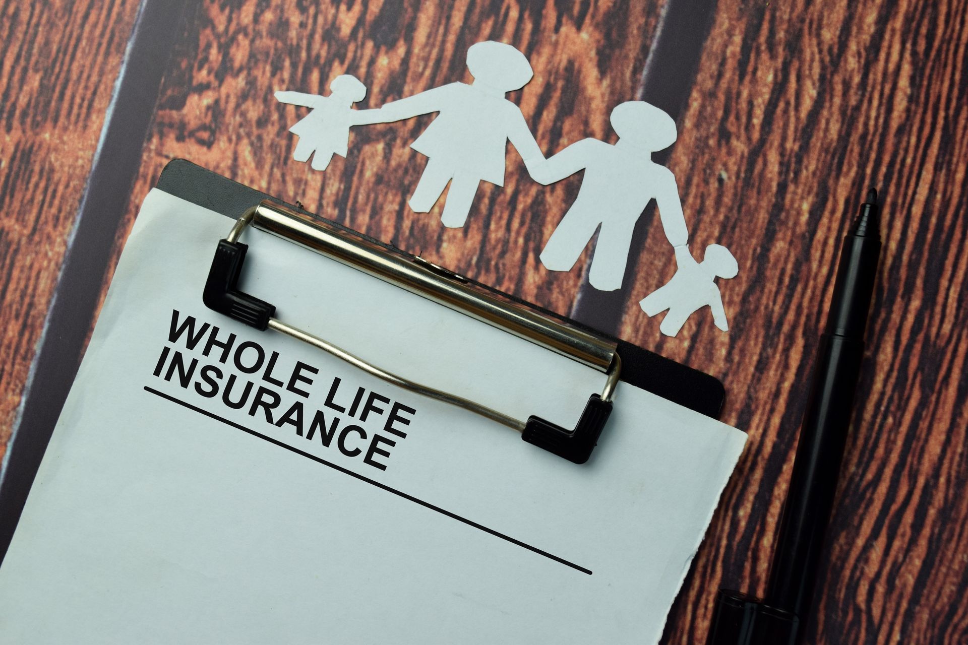 A clipboard with a whole life insurance form on it.