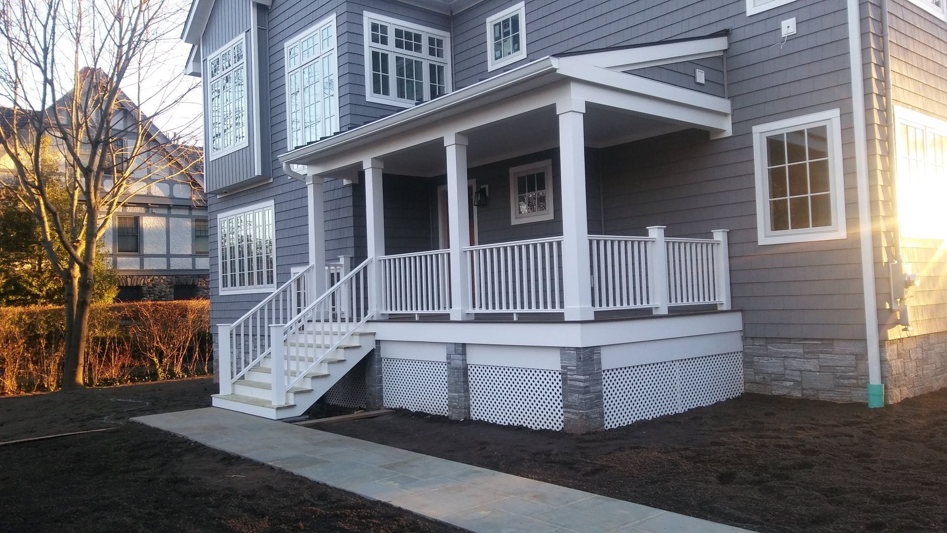 A gray house with a white porch and stairs