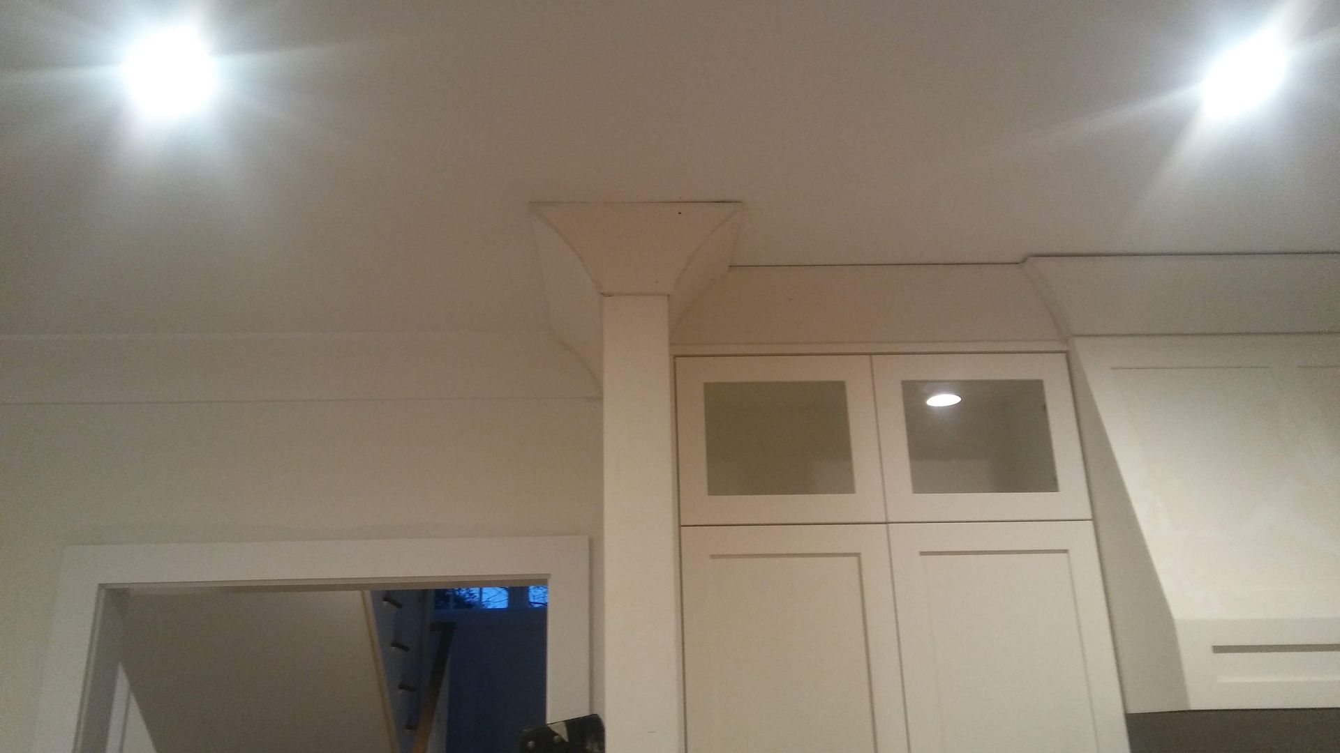 A kitchen with white cabinets and a ceiling light.