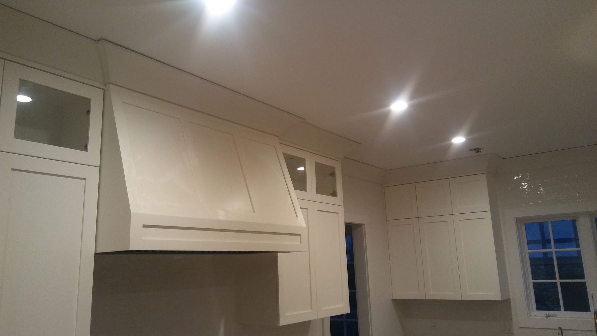 A kitchen with white cabinets and a stove top oven.