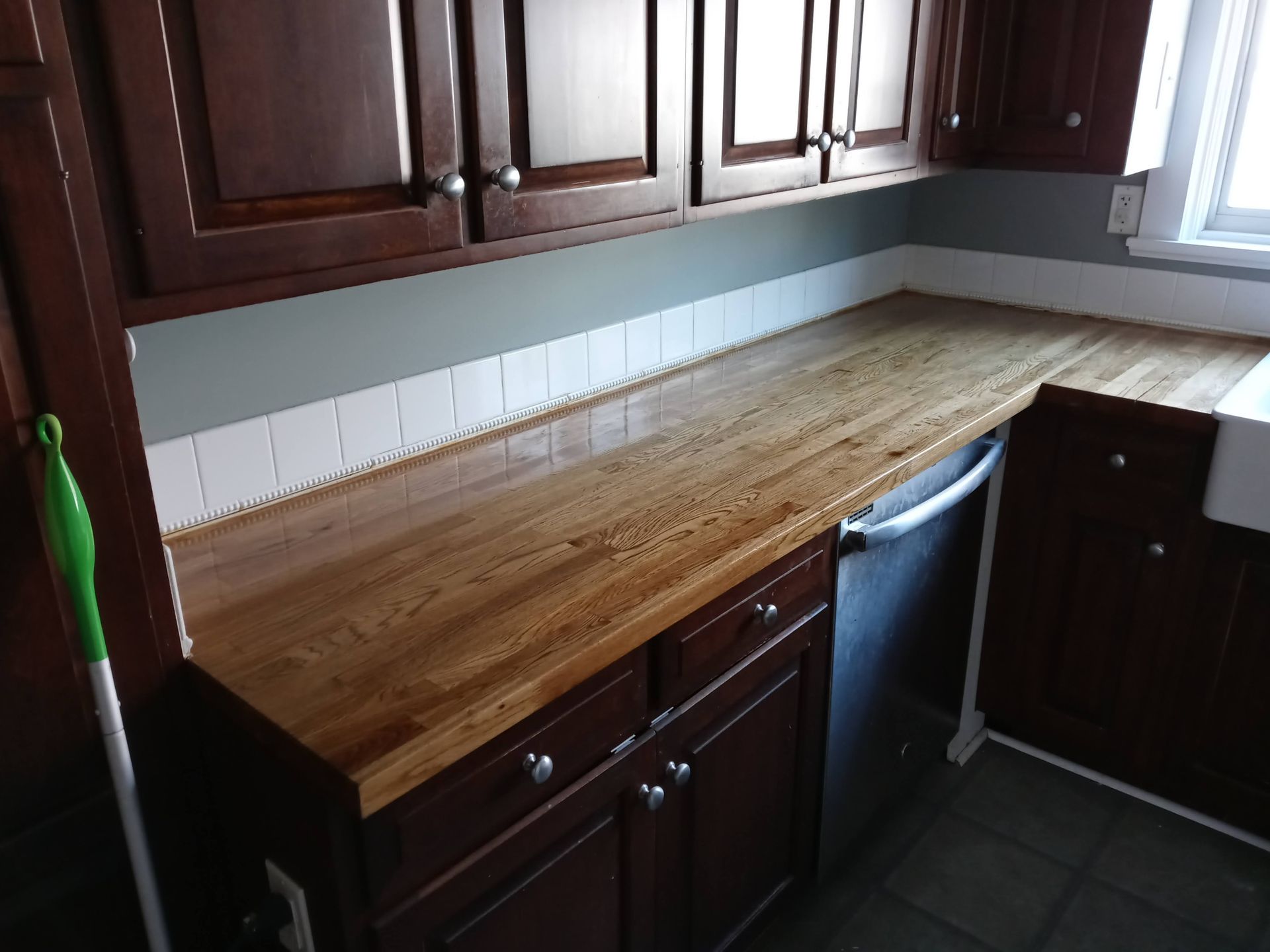 A kitchen with wooden cabinets and a wooden counter top