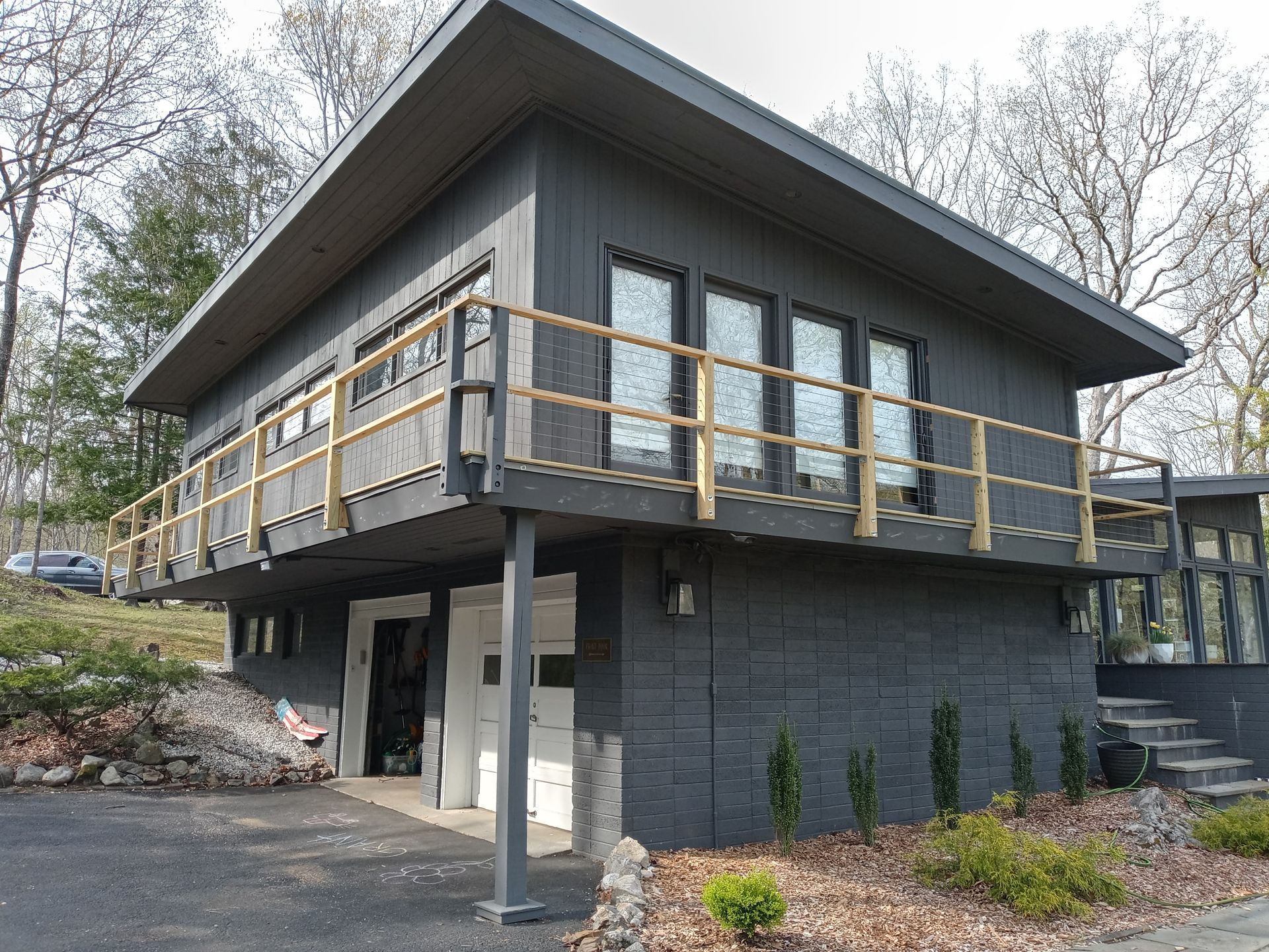 A black house with a balcony and a wooden railing