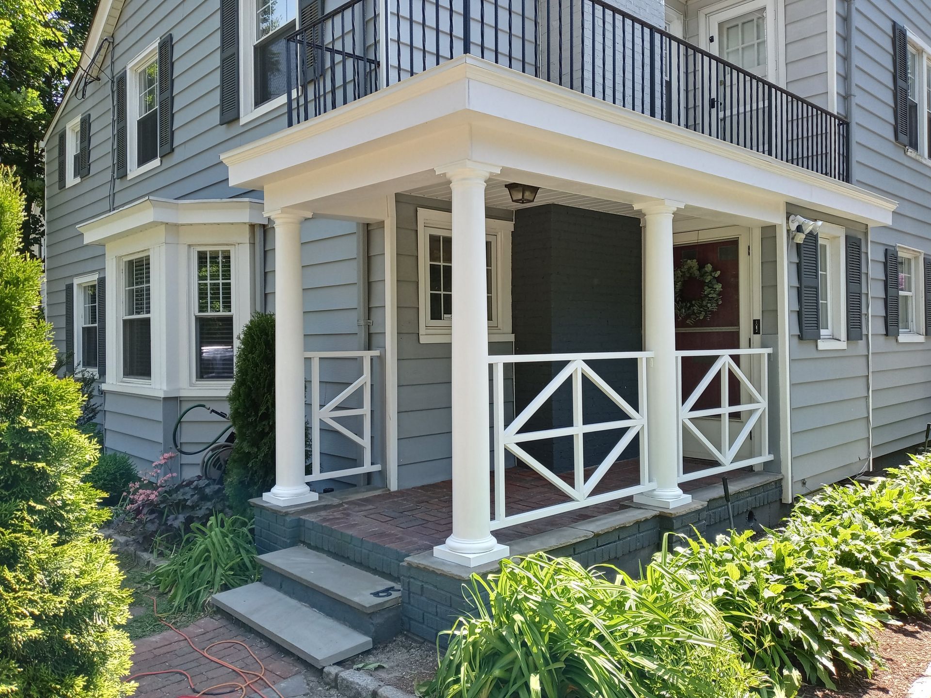 A gray house with a porch and stairs