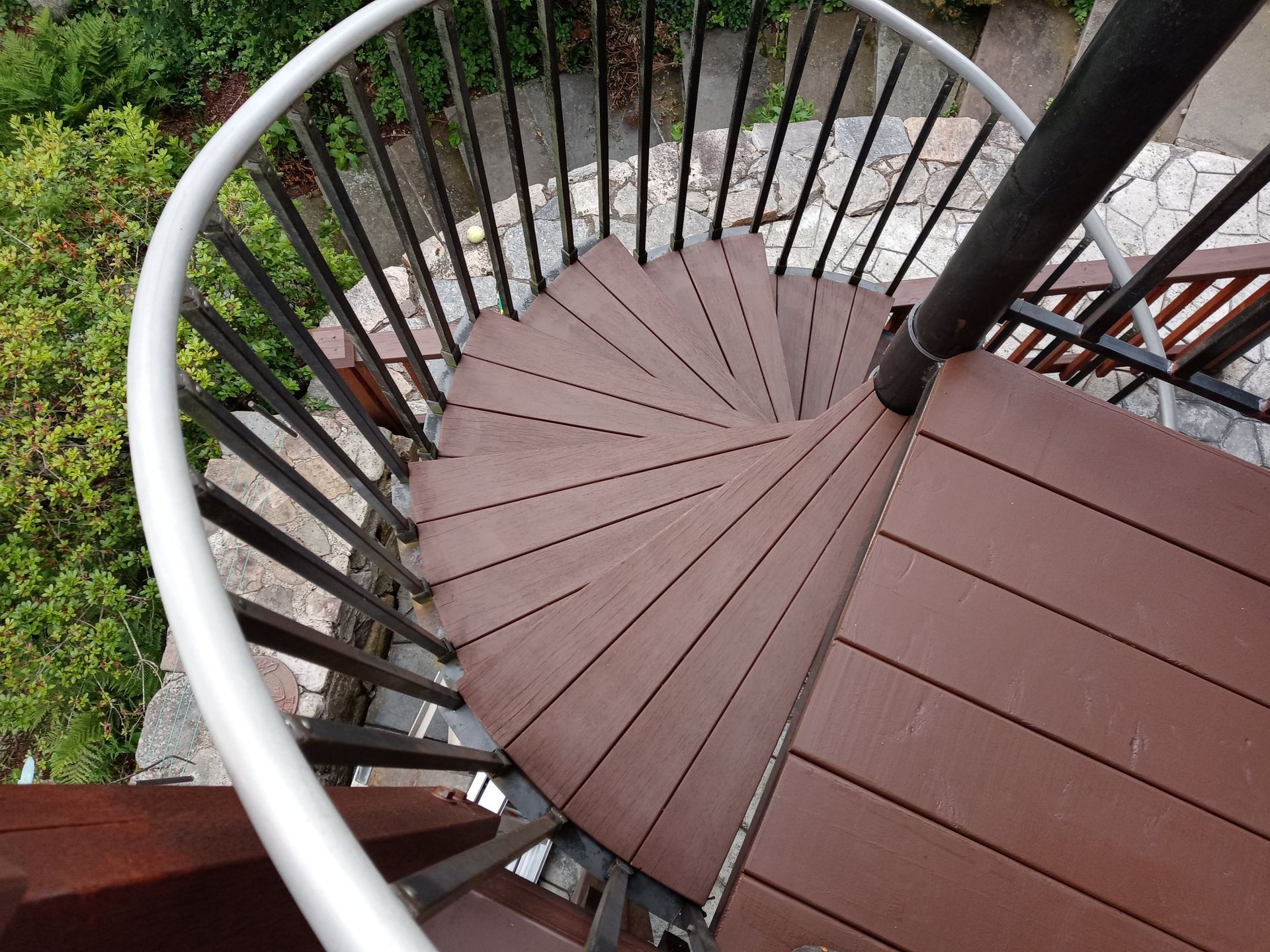 A spiral staircase with wooden steps and a metal railing