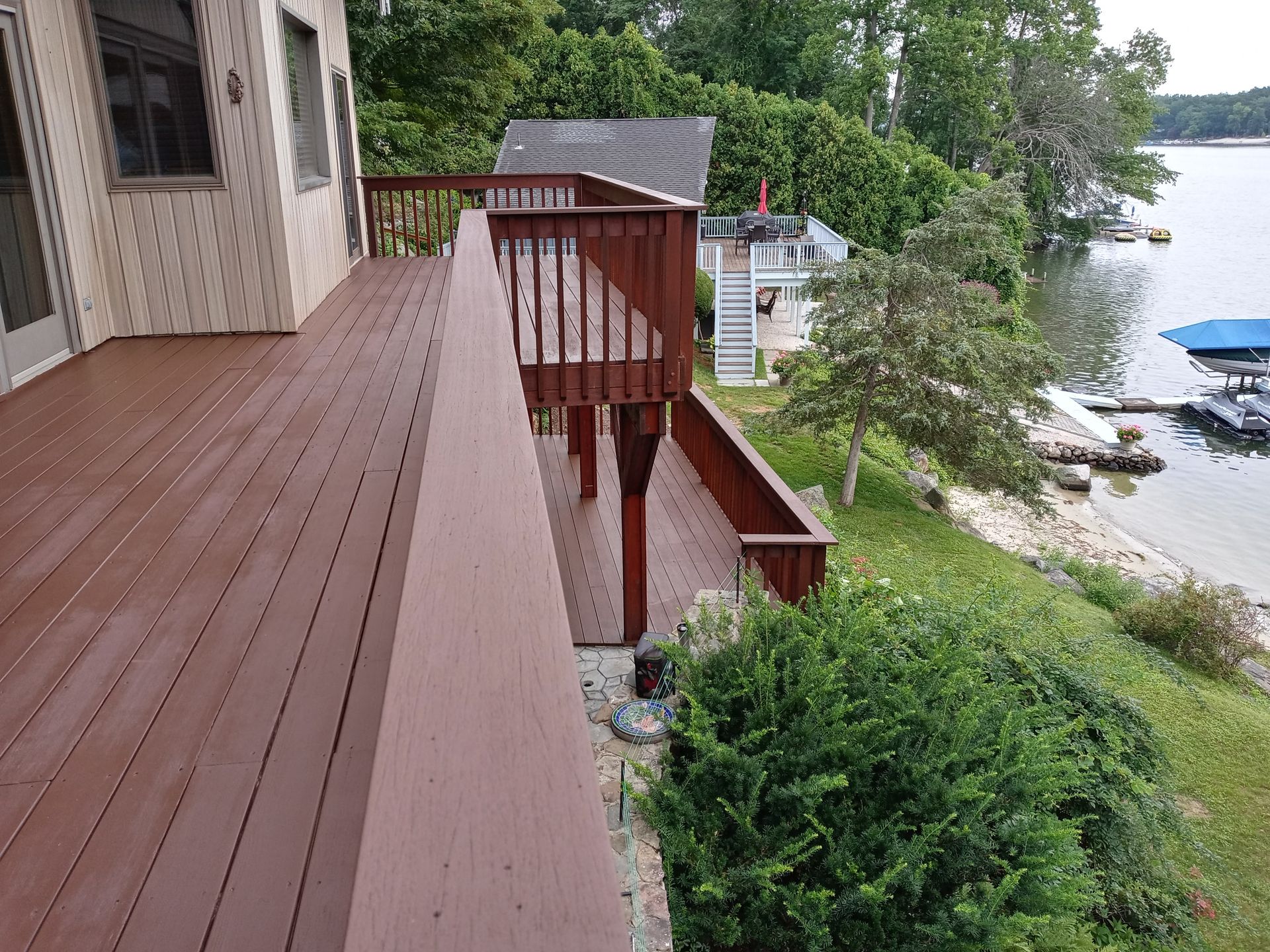 A large wooden deck with a view of a lake