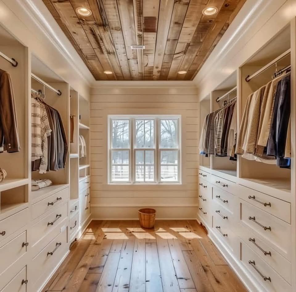 A walk in closet with lots of clothes and drawers