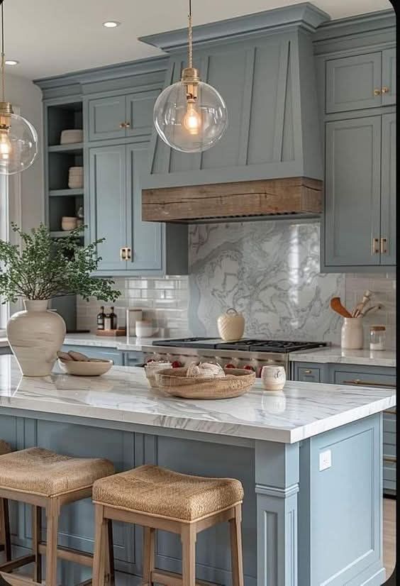 A kitchen with blue cabinets and a marble counter top.