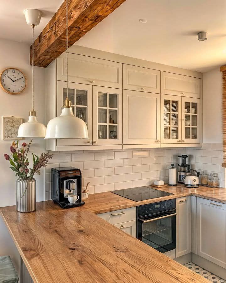 A kitchen with white cabinets and a wooden counter top
