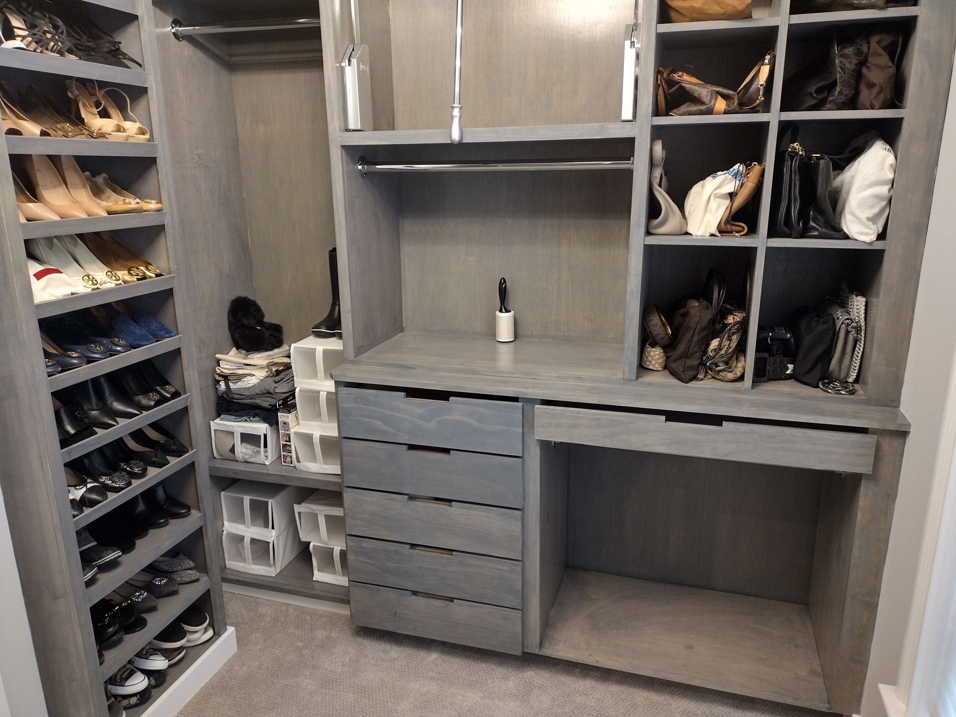 A walk in closet filled with lots of shoes and handbags.