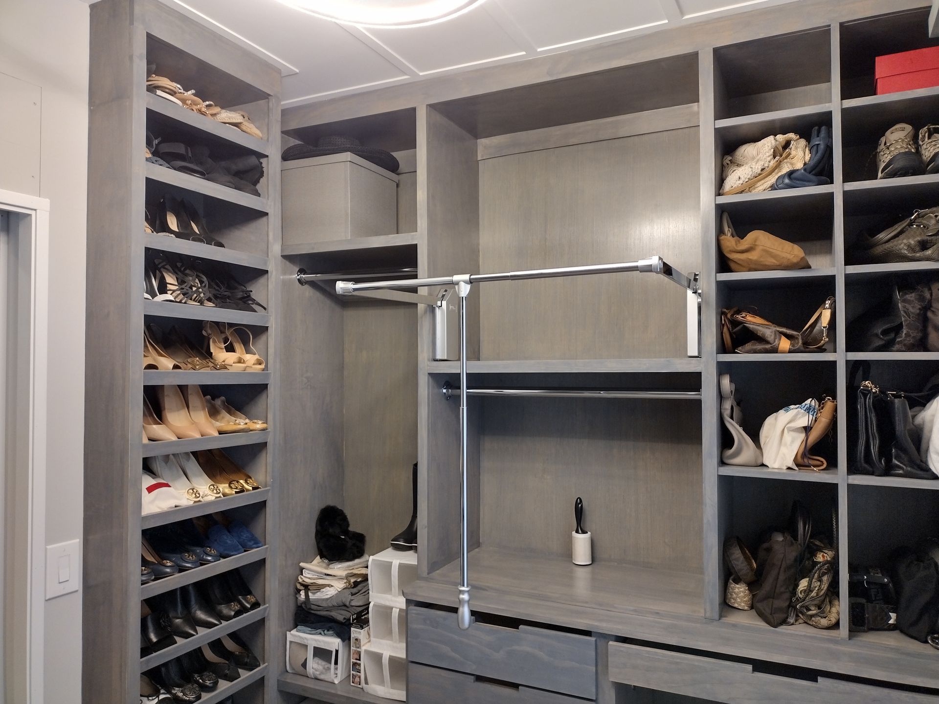 A walk in closet filled with lots of shoes and handbags.