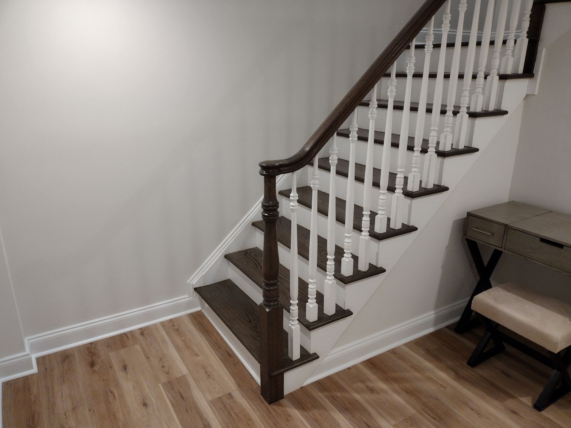 A staircase with wooden steps and white railings in a room.