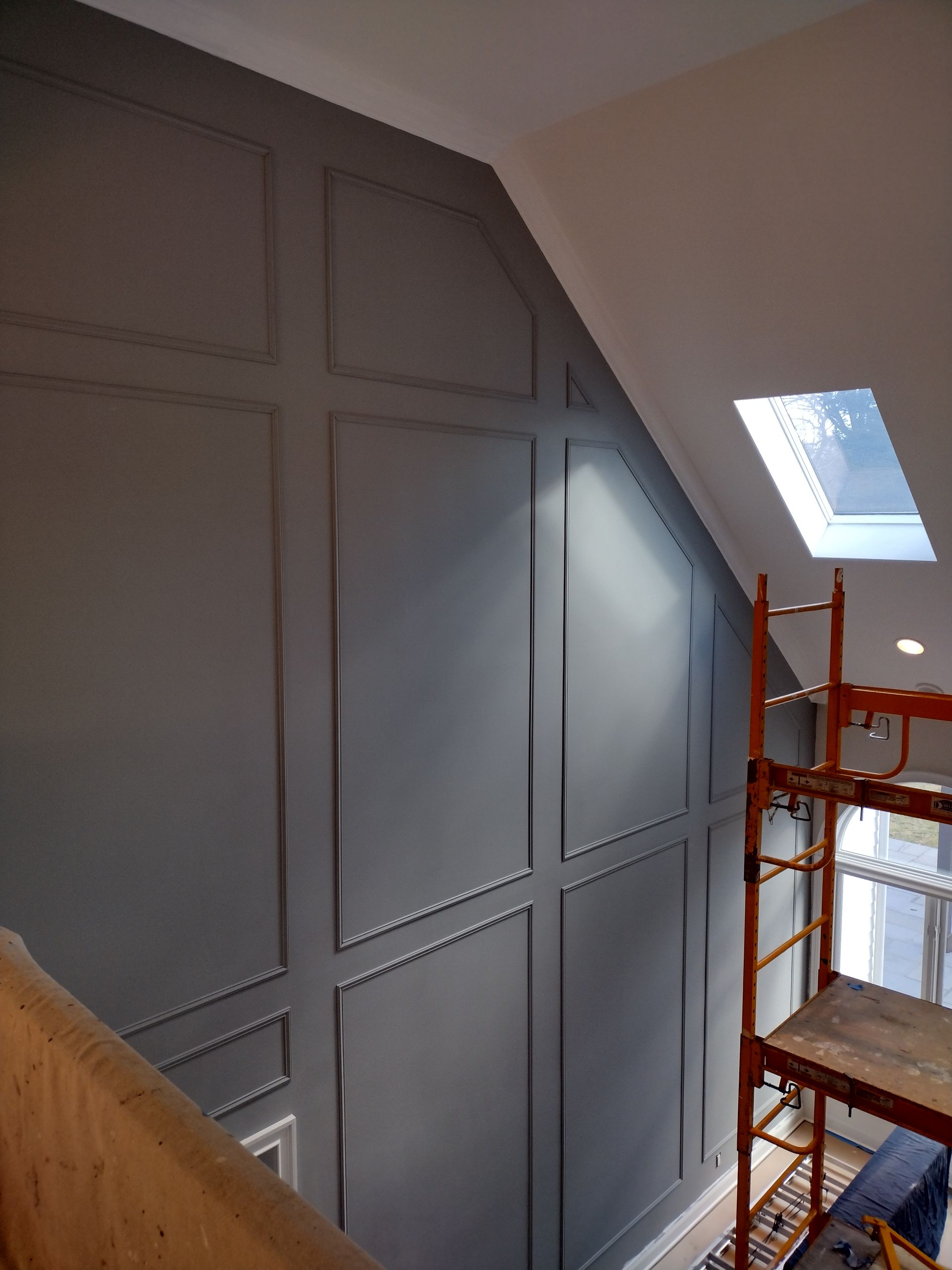A staircase with a scaffolding and a skylight on the ceiling.