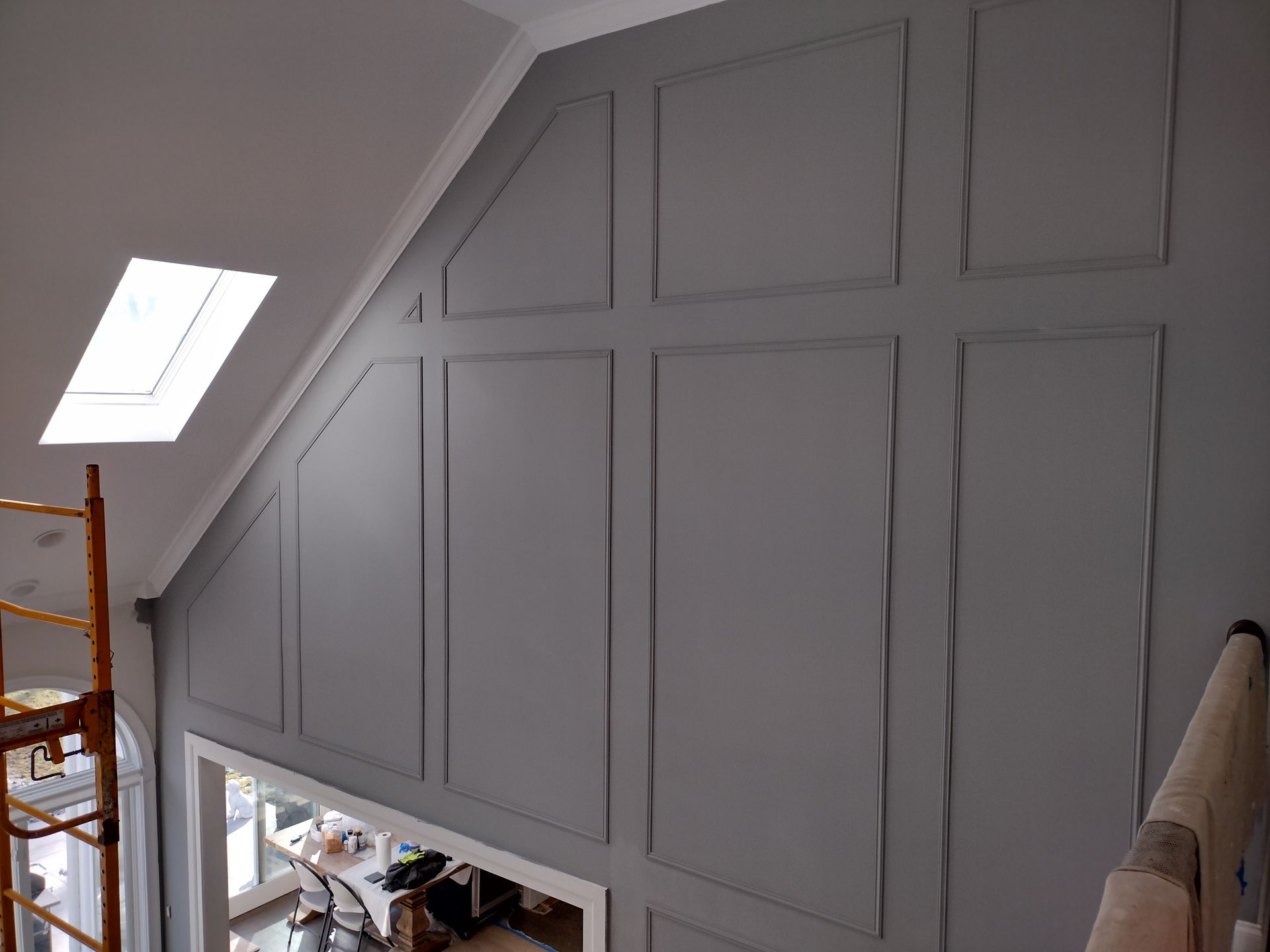 A room with a slanted ceiling and gray walls.