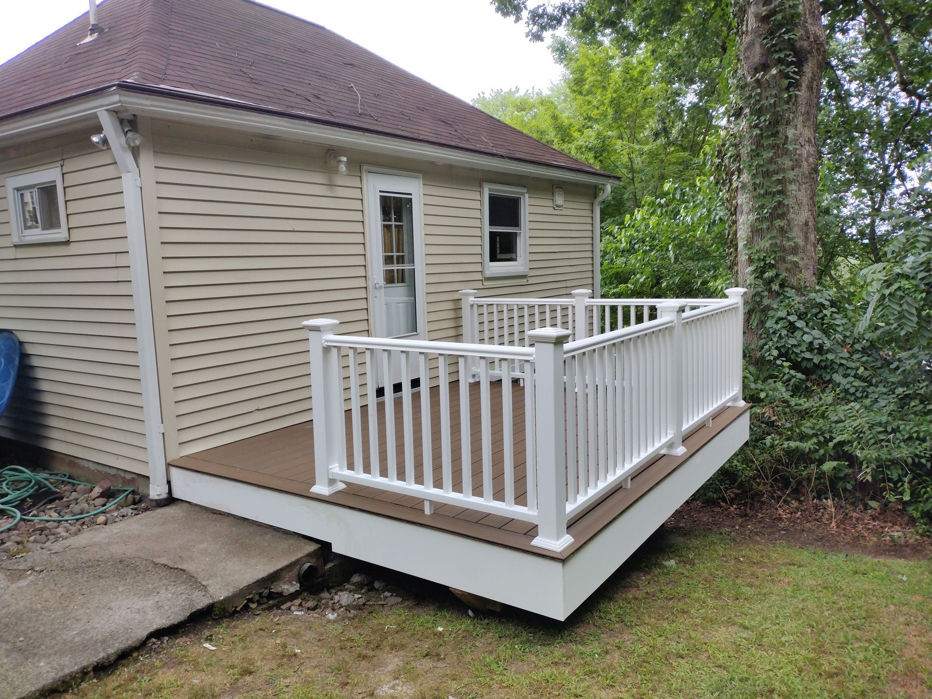A small house with a large deck in front of it.