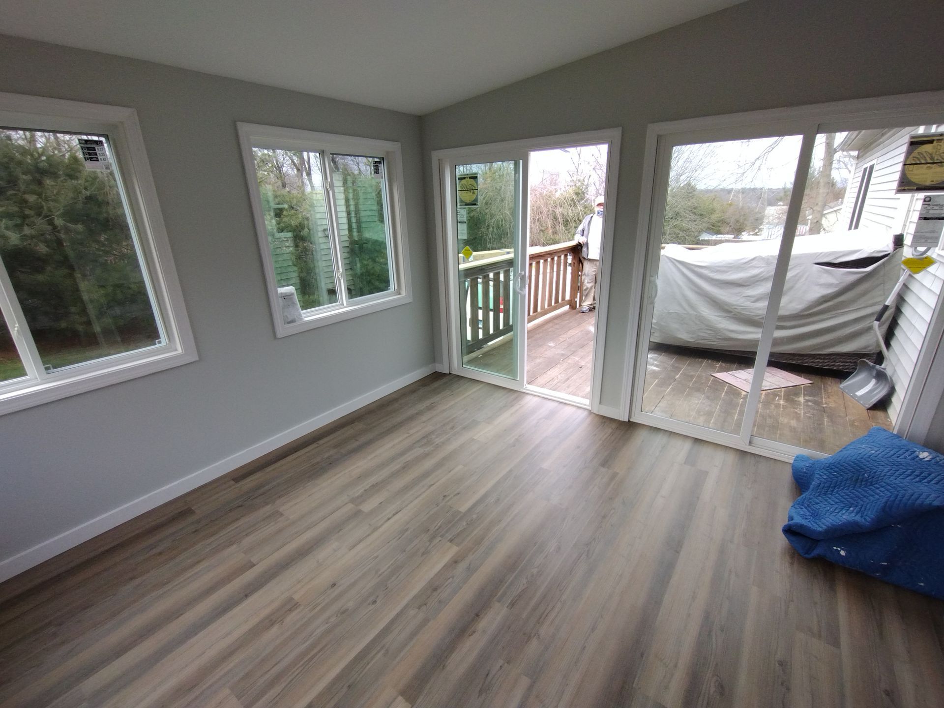 A room with hardwood floors and sliding glass doors leading to a deck.