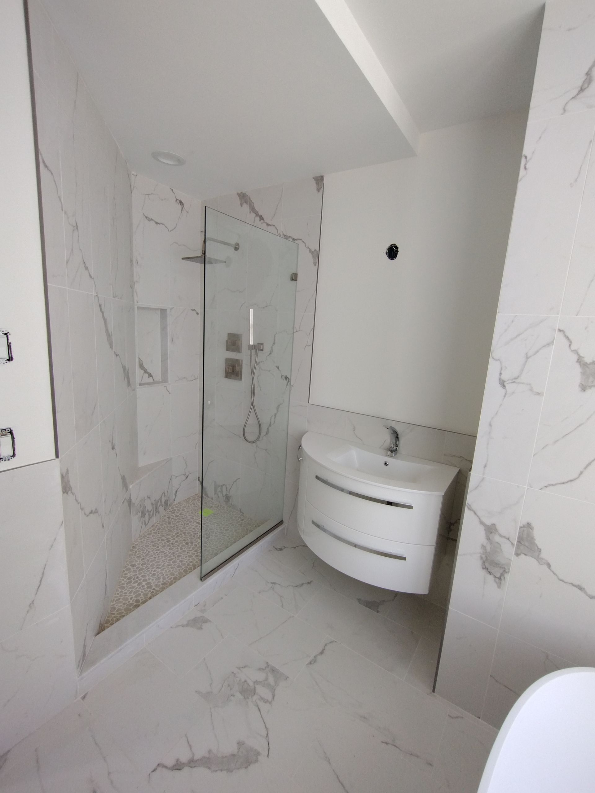 A bathroom with a sink and a walk in shower