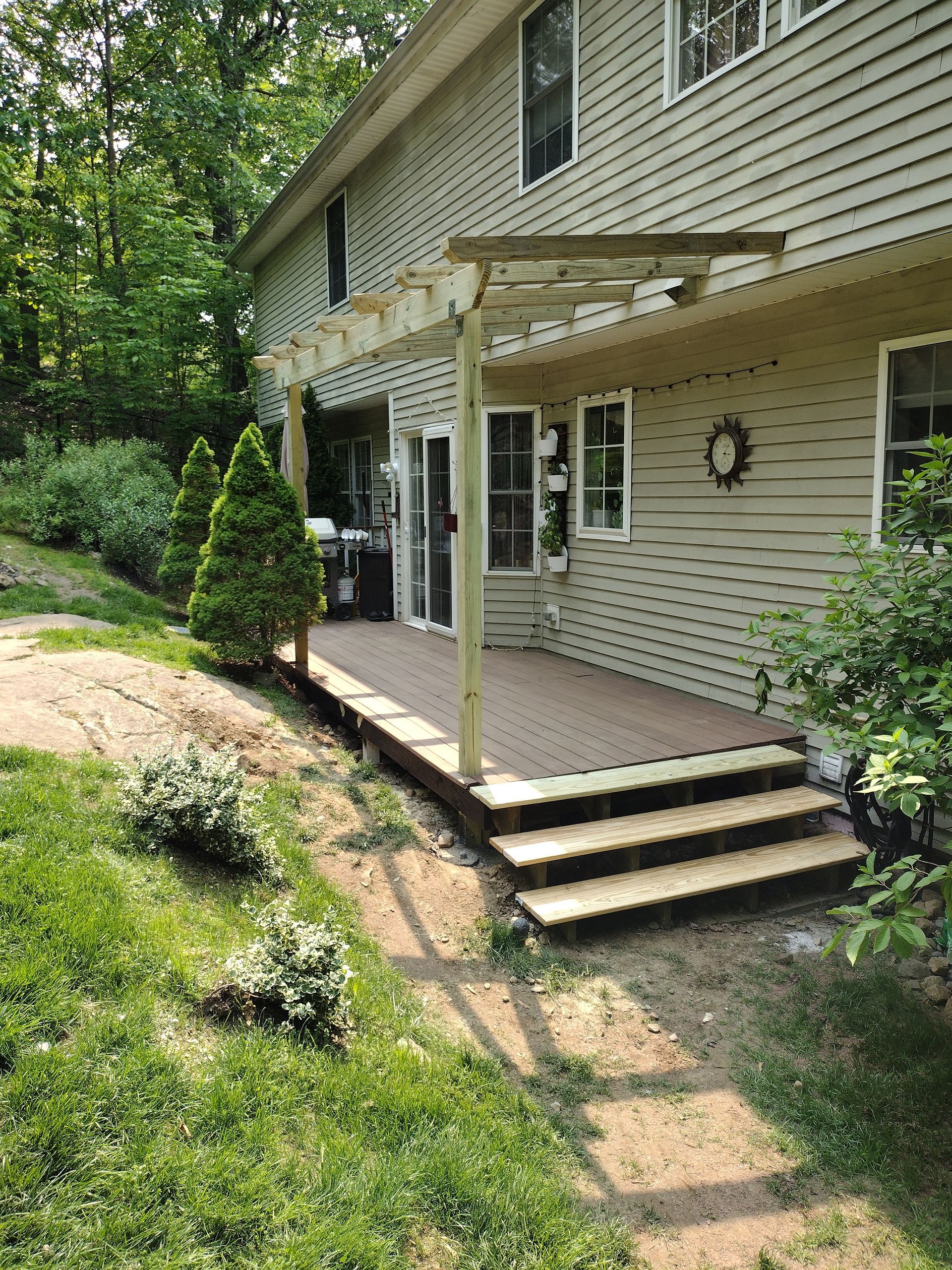 A house with a pergola and stairs in front of it.