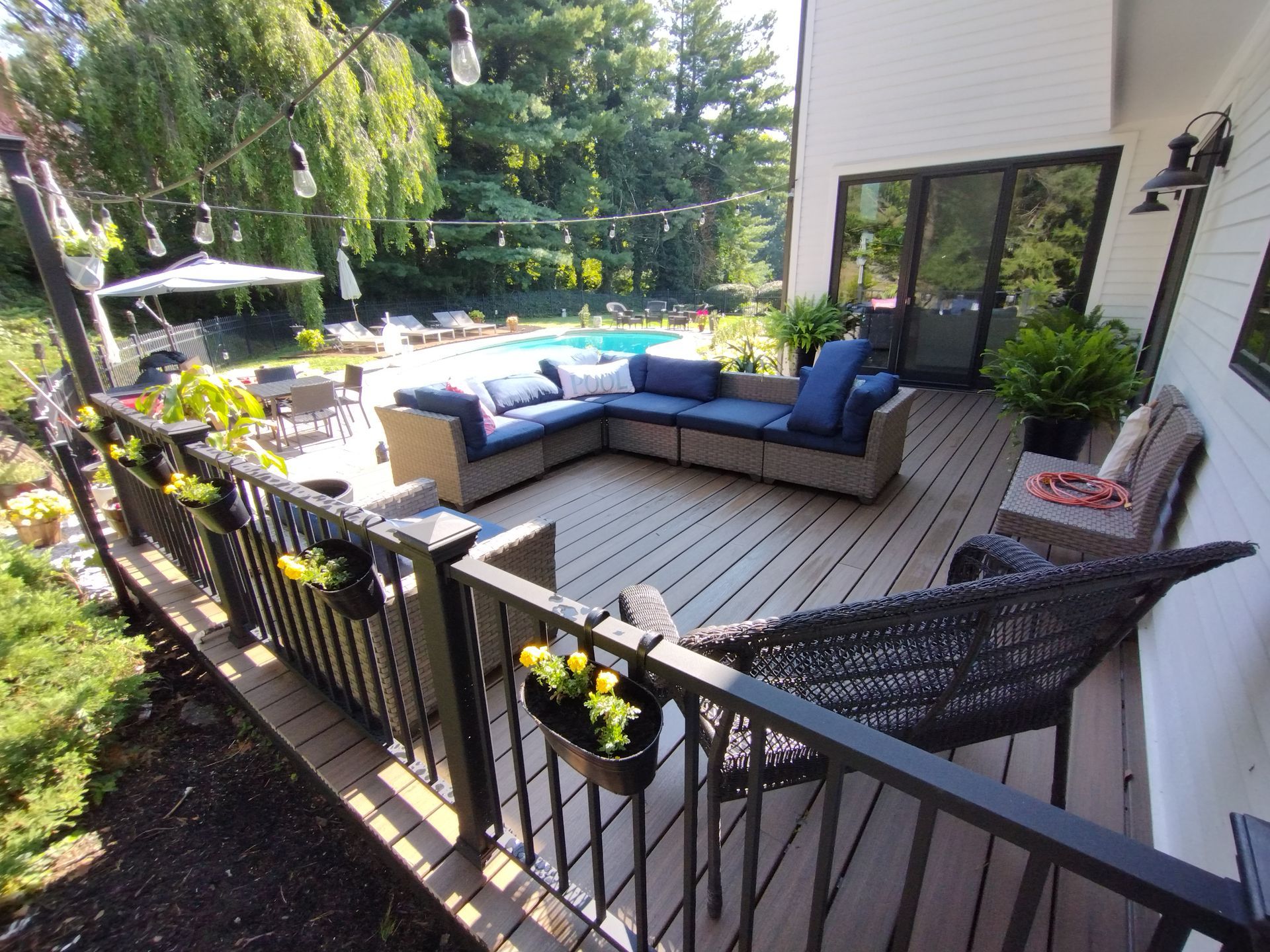 A large deck with a couch and chairs and a hammock.