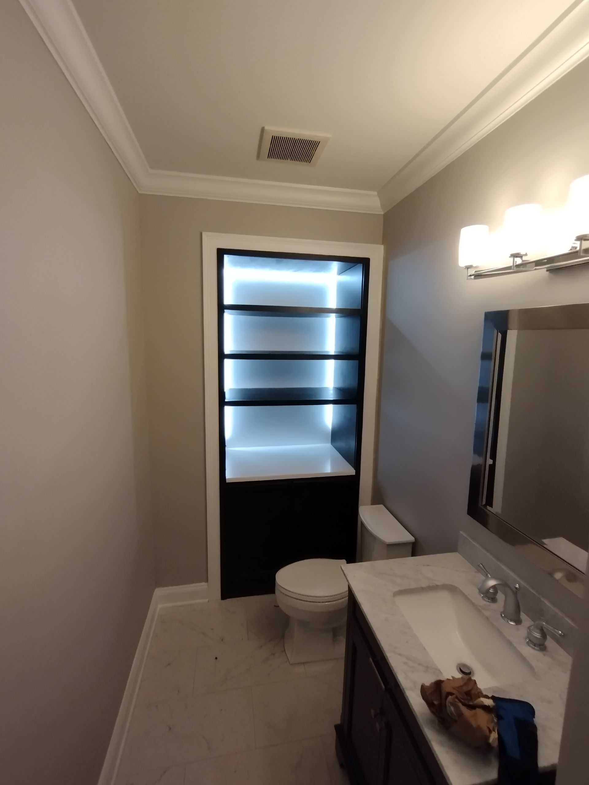 A bathroom with a sink toilet and mirror