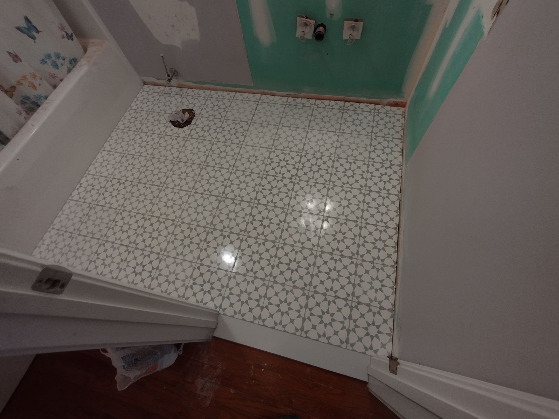 A bathroom with a white tile floor and a bathtub.