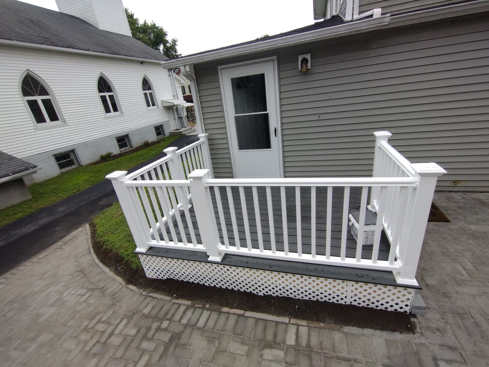 A white railing is sitting in front of a house.