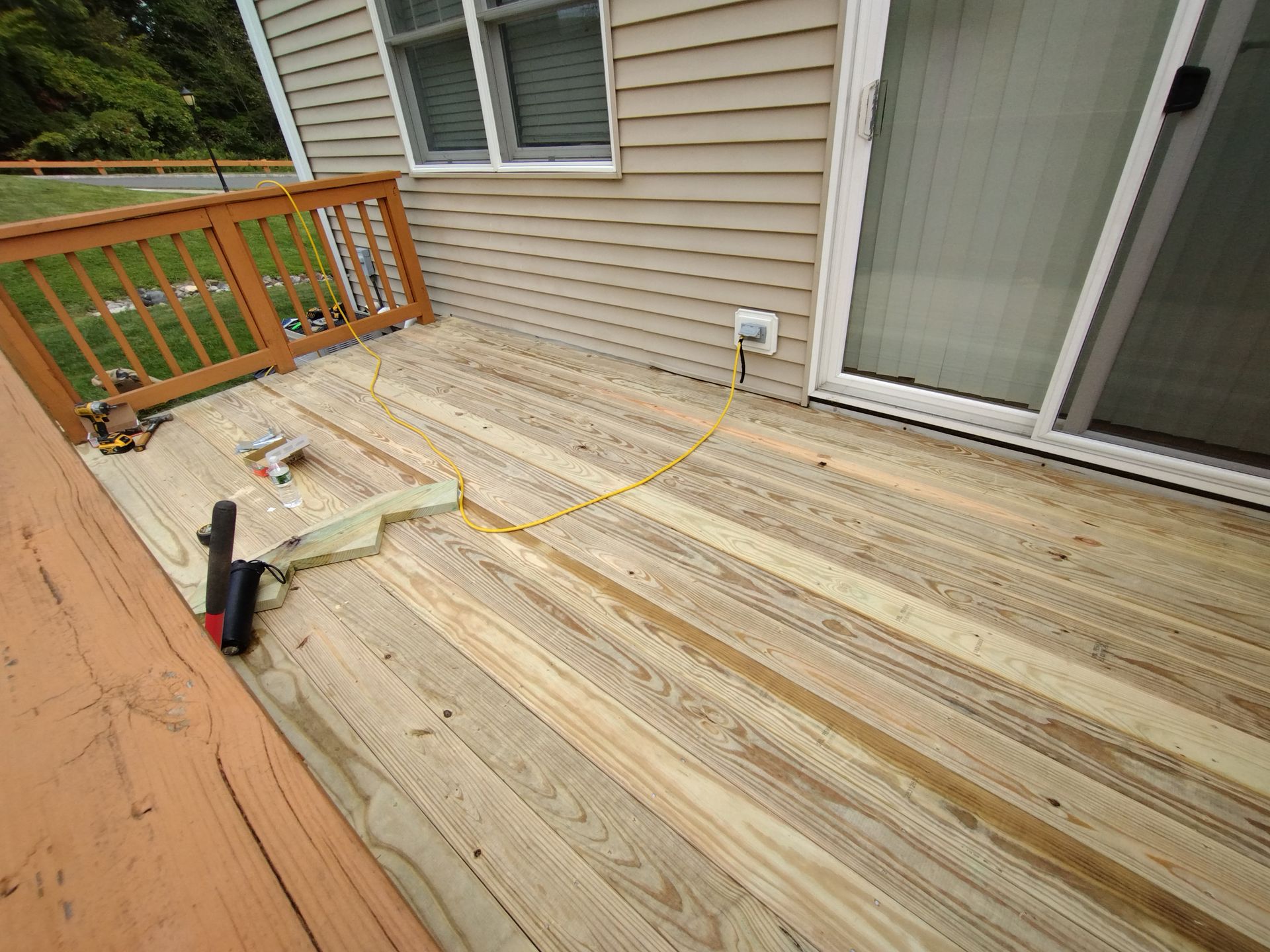 A wooden deck is being built in front of a house.