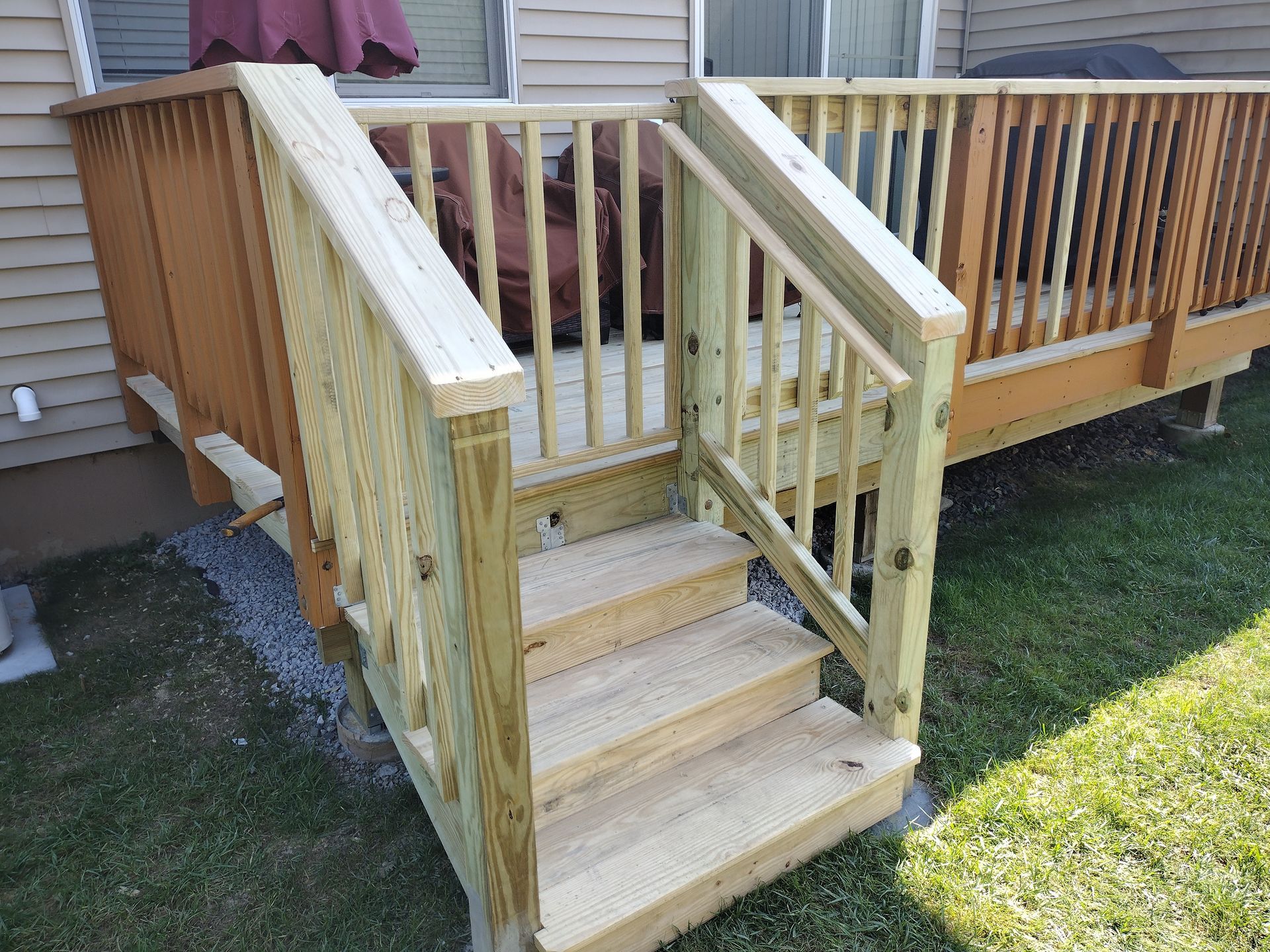 A wooden deck with stairs leading up to it.