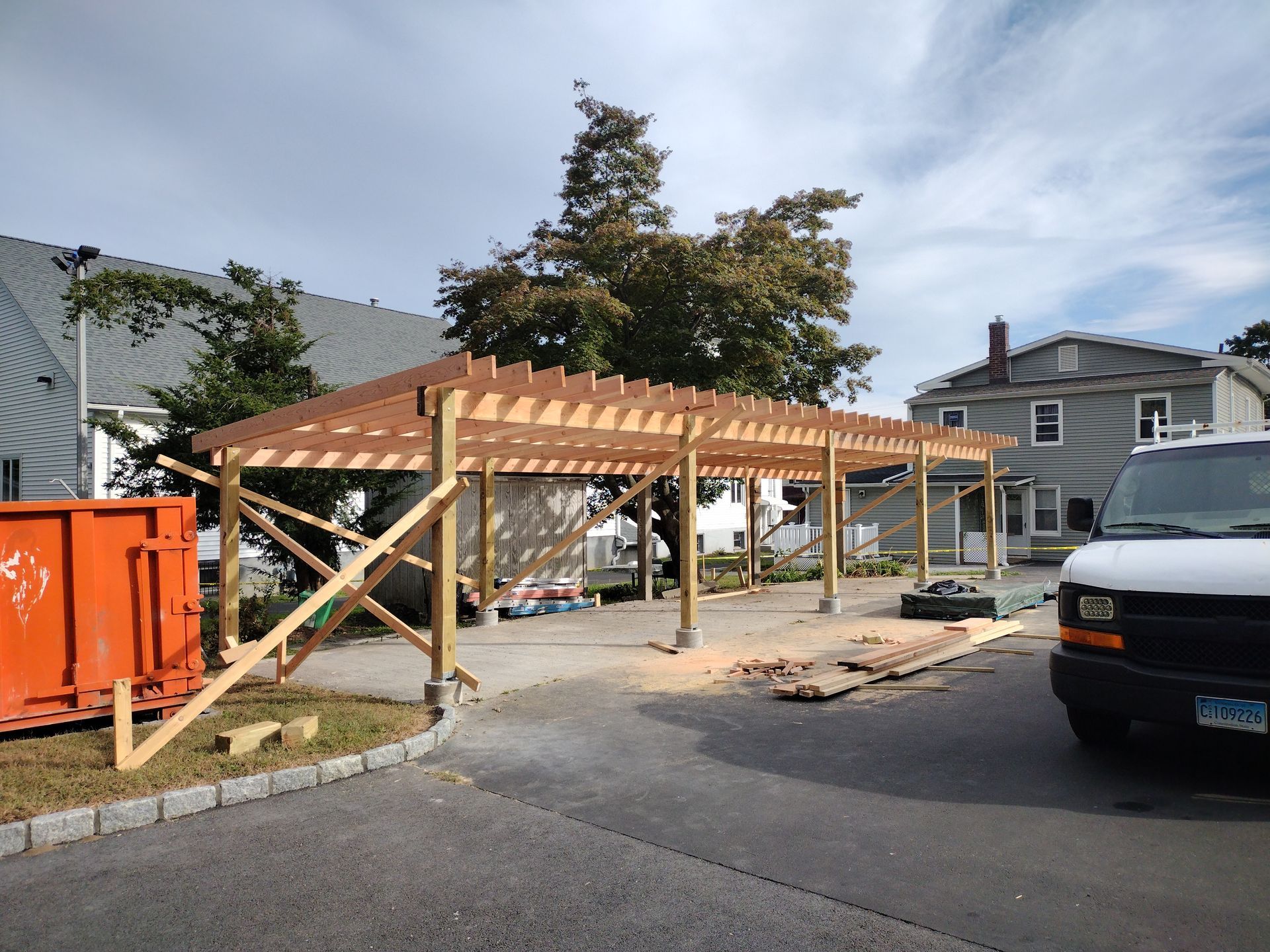 A white van is parked in front of a building under construction