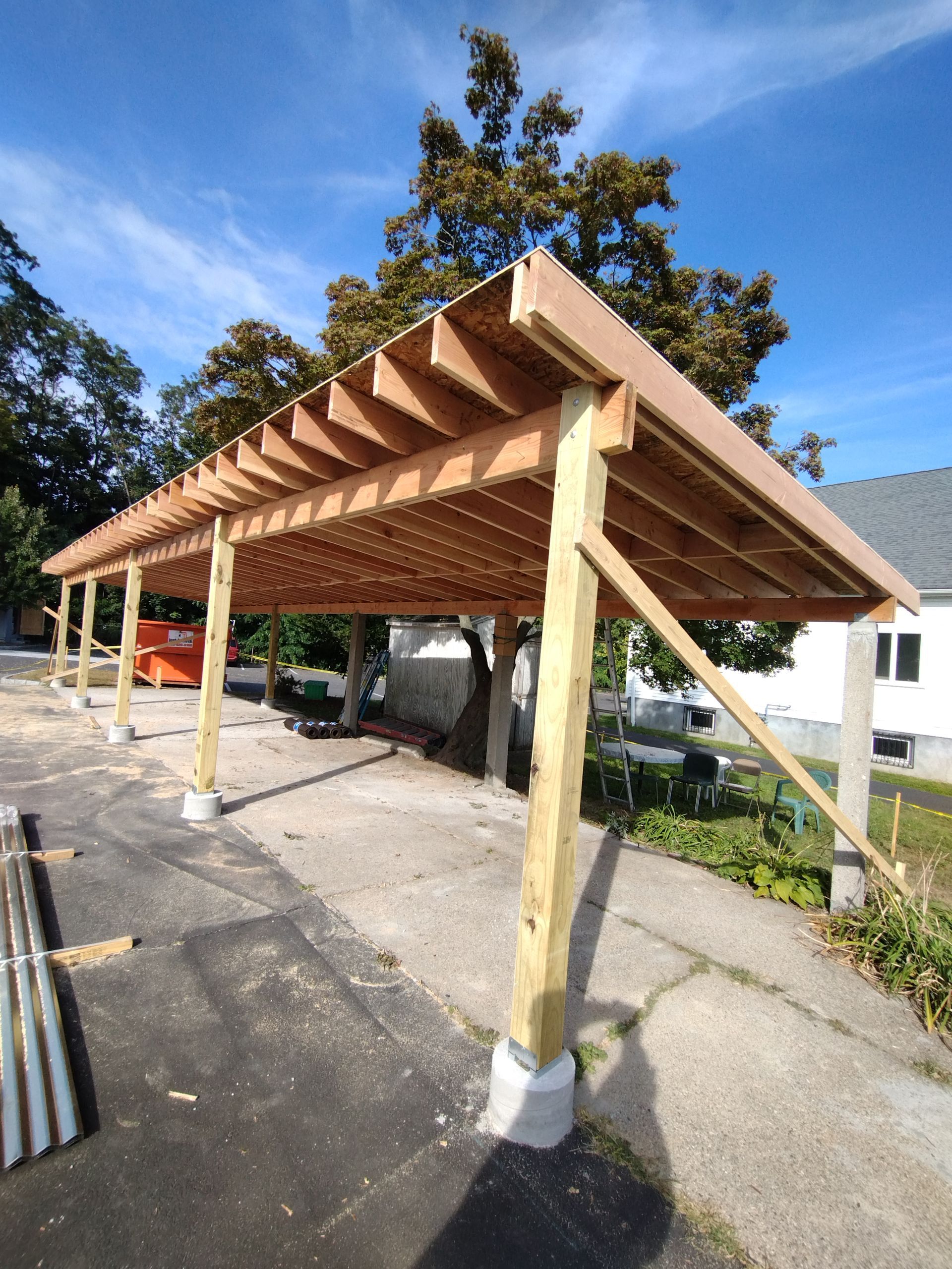 A carport is being built in front of a house