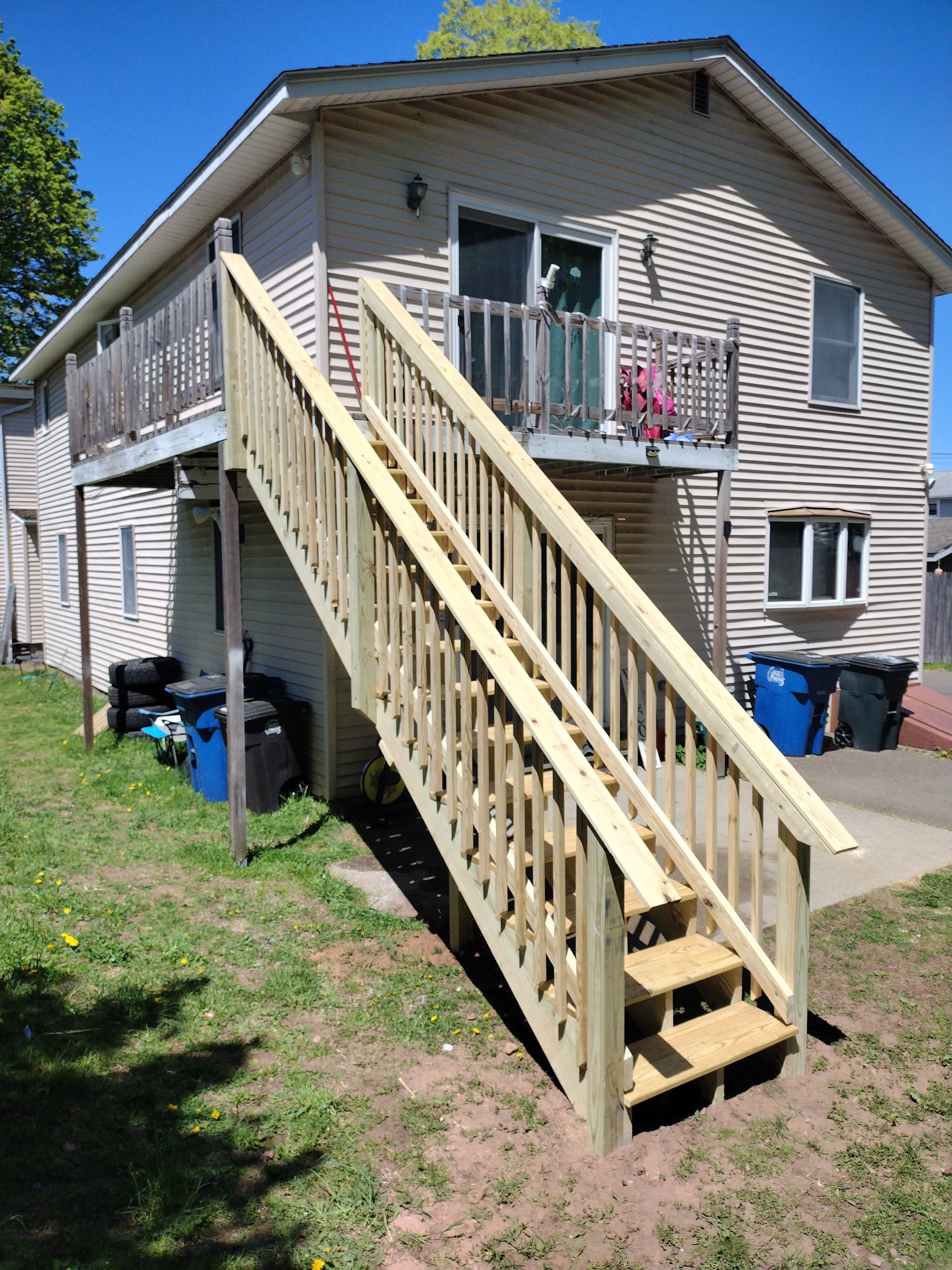 A house with a wooden deck and stairs leading up to it