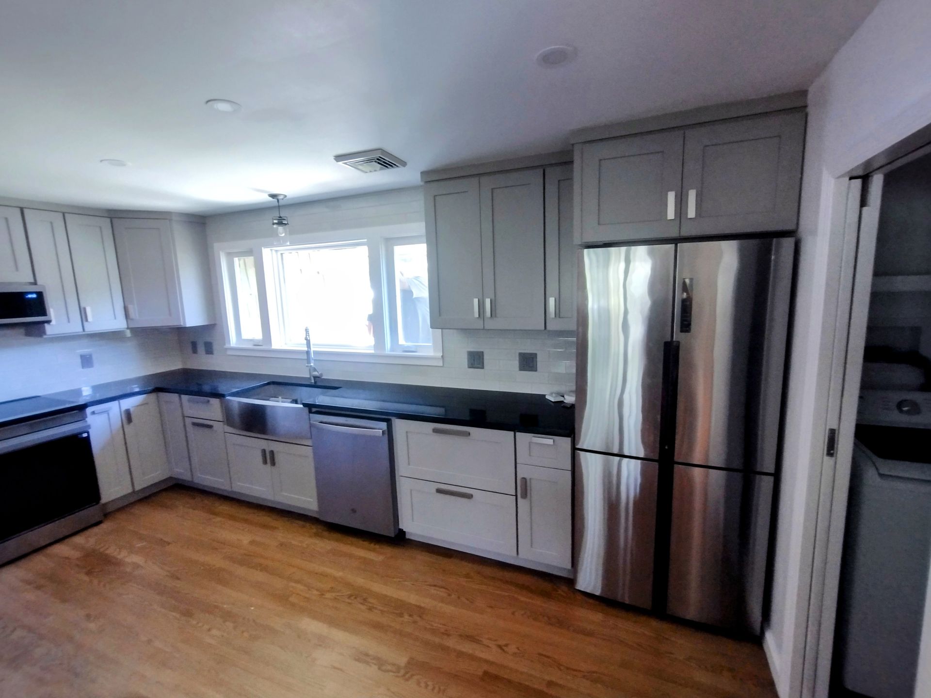 A kitchen with stainless steel appliances and white cabinets