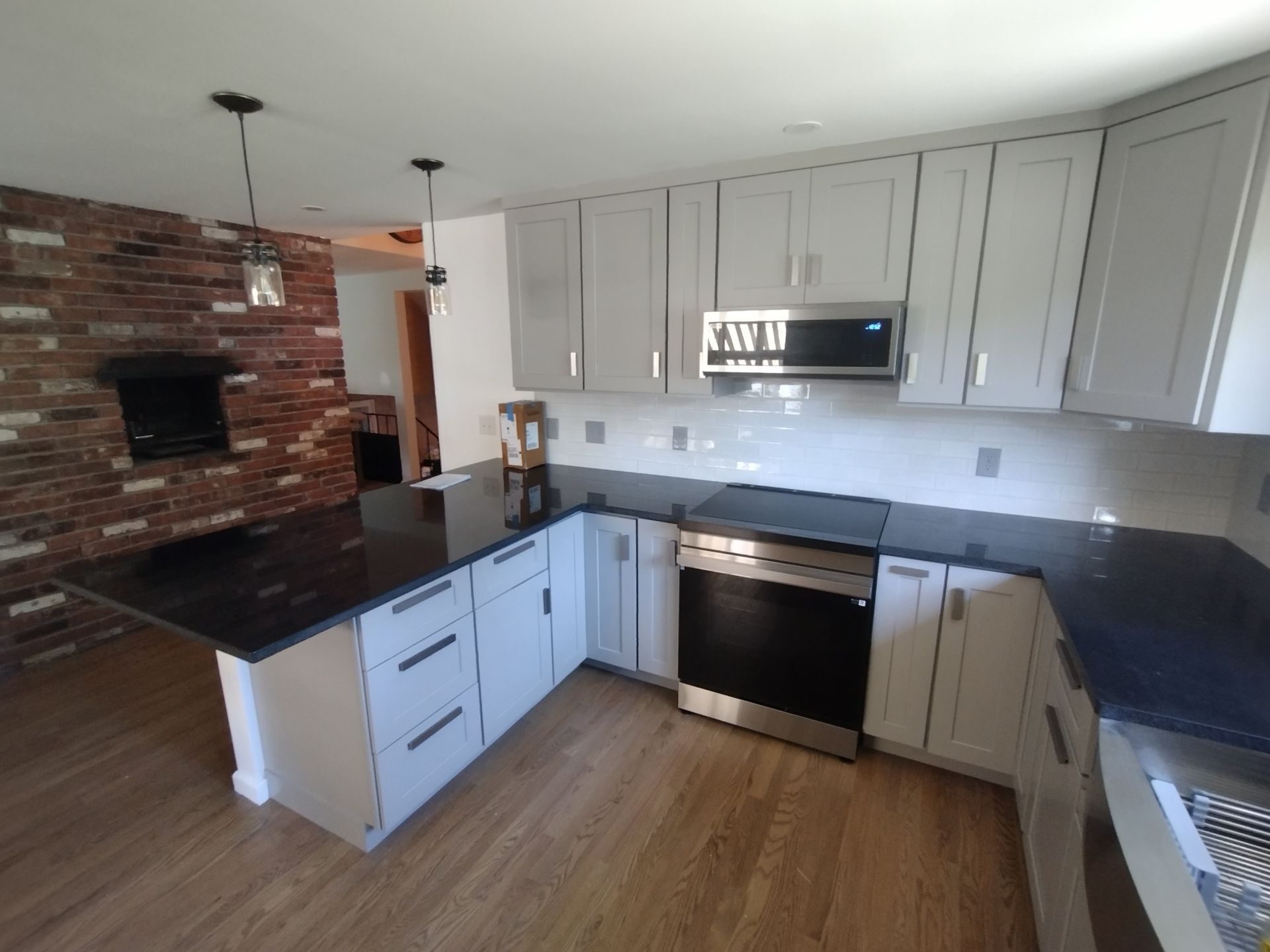 A kitchen with white cabinets and black counter tops