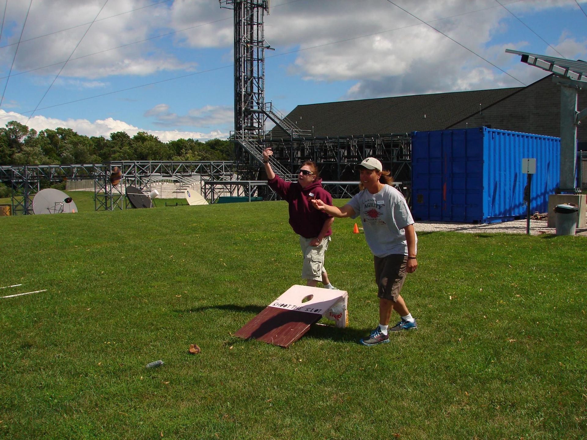 2 people playing a bag toss game outdoors