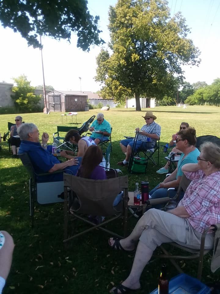 A group of people sitting on lawn chairs outdoors