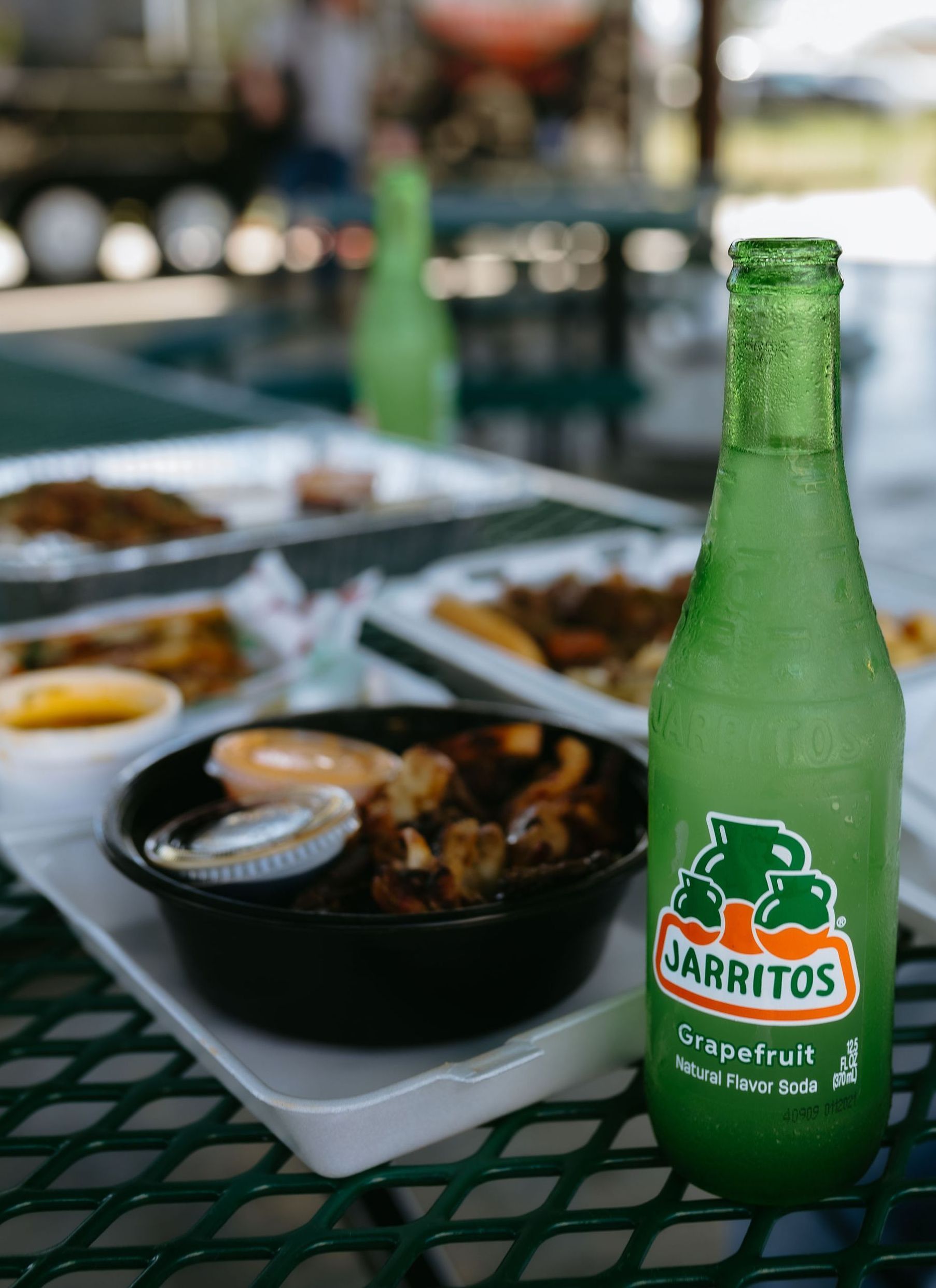 A person is holding a tray of food in front of a sign that says louisiana
