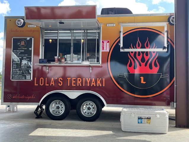 A lola 's teriyaki food truck is parked in a parking lot
