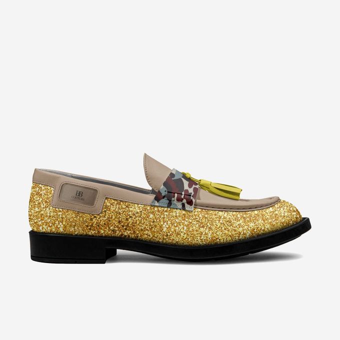 Glittery gold loafer with a floral accent and yellow tassel.